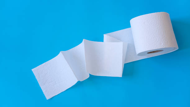 белые рулоны туалетной бумаги на синем фоне. концепция гигиены. - toilet paper стоковые фото и изображения