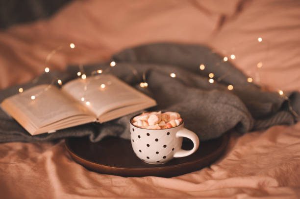 istock Cup of chocolate with marshmallow over Christmas light in bed 1439477006