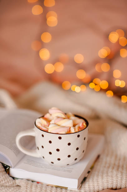 istock Cup of chocolate with marshmallow over Christmas light in bed 1439477012
