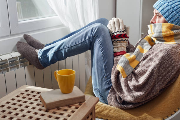 man with hat, sweater and hand gloves indoors on a chilly winter day, energy and gas crisis, cold room, heating problems. - scarf hat green glove imagens e fotografias de stock