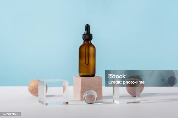 Oil Cosmetics Amber Product Packaging With Stylish Props Serum Cosmetic Bottle With Peptides And Retinol On Acrylic And Wooden Blocks On Blue Background Serum Dropper Mockup On Pedestal Podium Stock Photo - Download Image Now