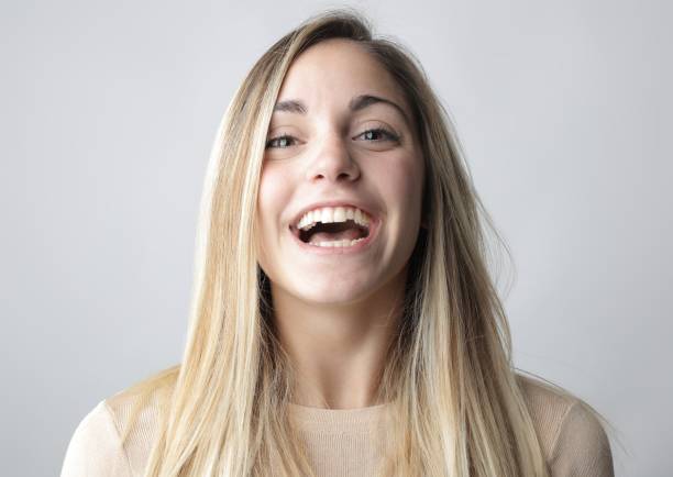 istock Smiling blonde woman behind a white background 1439492716