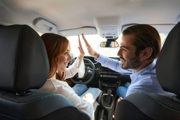 istock Car driver and her passenger high-fiving one another 1439493129