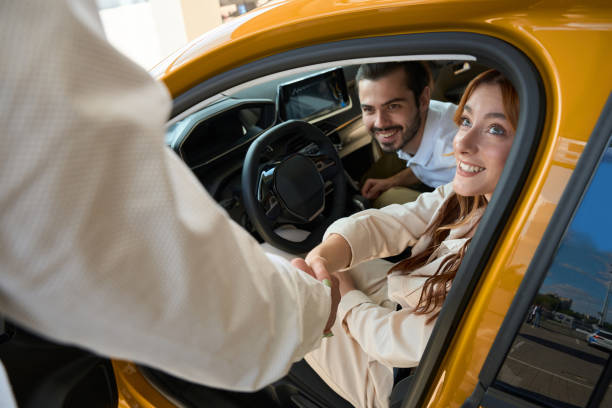 istock Dealership sales representative congratulating customer on new vehicle purchase 1439493666