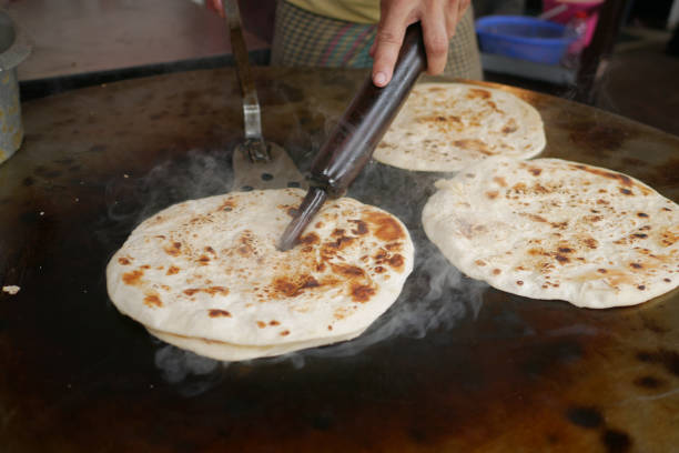 cooking roti chapati on a big cooking pan cooking roti chapati on a big cooking pan , One Chapati stock pictures, royalty-free photos & images