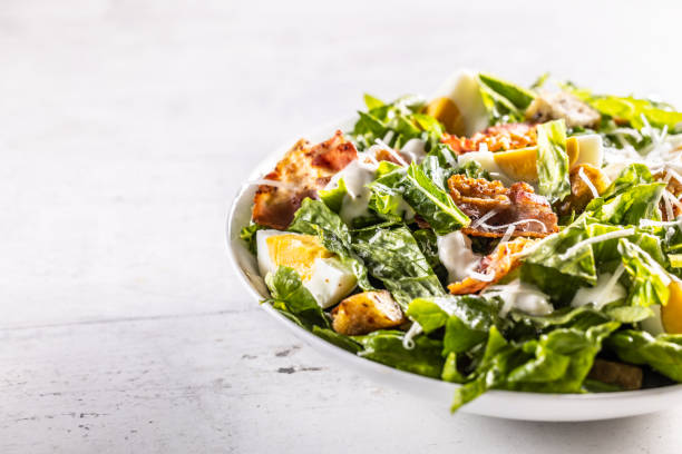 istock Caesar salad prepared from romaine lettuce, baked bacon, egg, bread croutons, garlic dressing and grated Parmesan cheese. 1439495376