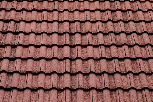 New roof with ceramic tiles, Orange roof tiles - European rounded roof-tiles, Brown terra cotta roof tiles texture and background seamless.
