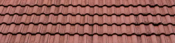 New roof with ceramic tiles, Orange roof tiles - European rounded roof-tiles, Brown terra cotta roof tiles texture and background seamless.