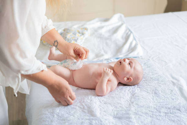 istock Cute baby in bedroom getting diaper changed. 1439496037