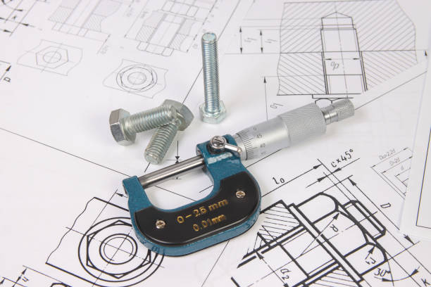 istock micrometer and bolts on a background of engineering drawings. Science, mechanics and mechanical engineering. 1439498307
