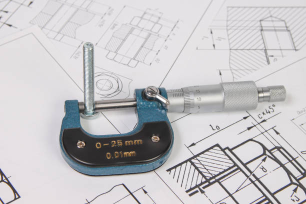 istock micrometer and bolts on a background of engineering drawings. Science, mechanics and mechanical engineering. 1439498387