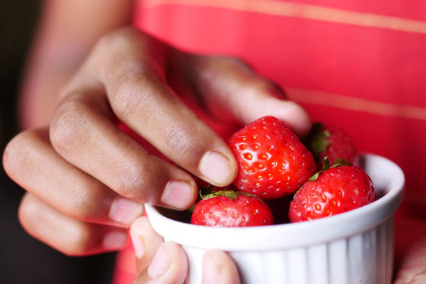 istock hand pick a Ripe Red Strawberries 1439498508