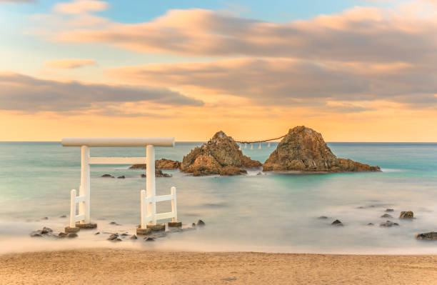fotografia di paesaggi marini a lunga esposizione delle meoto iwa couple rocks di sakurai futamigaura al tramonto. - ise foto e immagini stock