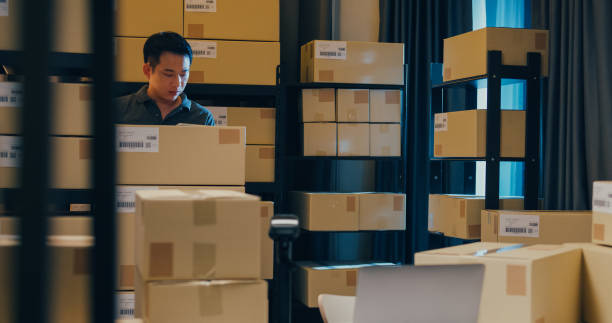 istock Asian businessman use barcode scanner scan paper box in shelf and put data in digital tablet cut stock online data information detail for express delivery at warehouse. 1439502510
