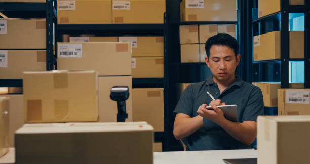 istock Asian businessman with barcode machine and box use digital tablet checking stock on shelf and key data in online information detail in before express delivery at warehouse. 1439502548