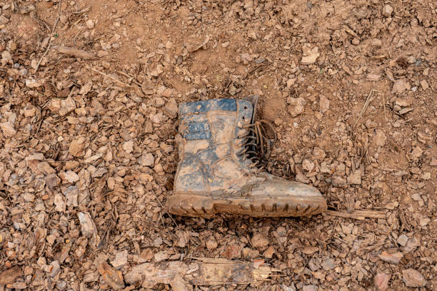 istock dirty boots on the ground. Losses in battle. 1439506110
