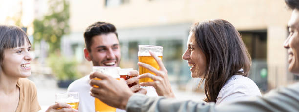 istock Horizontal banner or header with multiracial friends drinking beer at brewery pub - Genuine friendship life style concept with guys and girls enjoying happy hour food together at open air bar dehor 1439507414