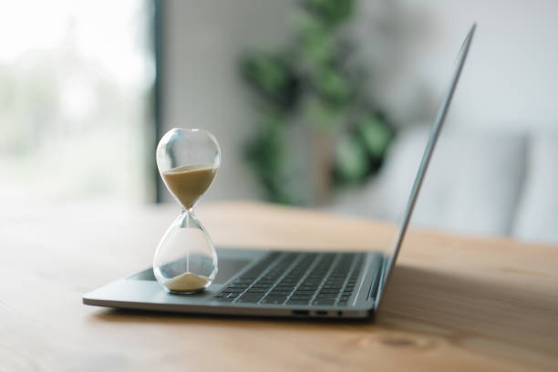 istock Hourglass on a laptop computer. Concept for time management and counting down to a deadline. concept of time management, business schedule, and deadline 1439509477