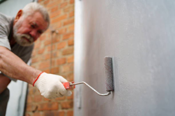 istock selective focus. an elderly man paints the metal garage door with a roller. 1439512940