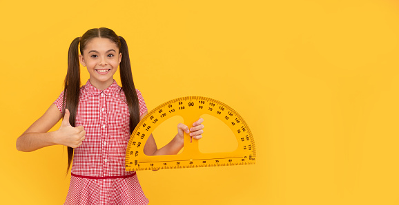 algebra and geometry. kid study math. modern education. measurement. trigonometry stationery. mathematics. measuring and sizing. thumb up. happy teen girl hold protractor ruler. back to school.