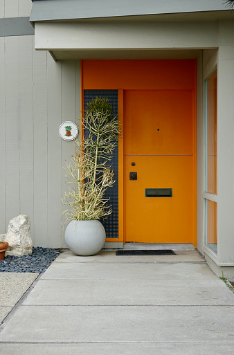 Tangerine orange front door on a mid-century modern home