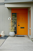 istock Tangerine orange front door on a mid-century modern home 1439515514