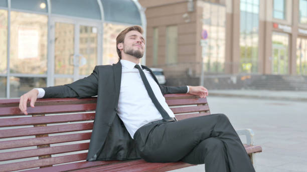 istock Relaxing Businessman Sitting Outdoor on Bench 1439516424