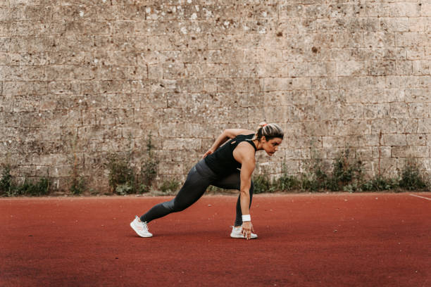 istock Young Woman Stretching Before Jogging On A Running Track 1439517188