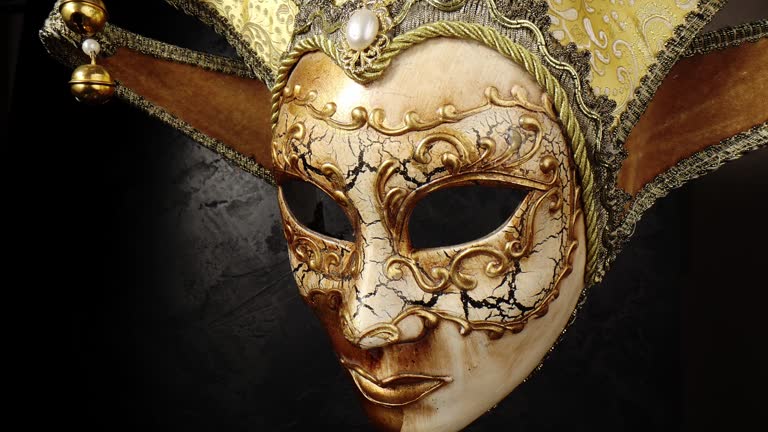 Venetian mask on a black background. Gilded mask on a stone black wall background.