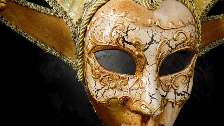 Venetian mask on a black background. Gilded mask on a stone black wall background.