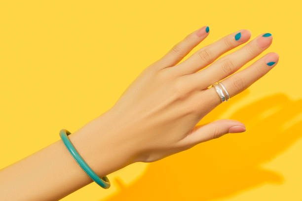 istock Womans hand with summer manicure on yellow background. Manicure design trends. 1439520971
