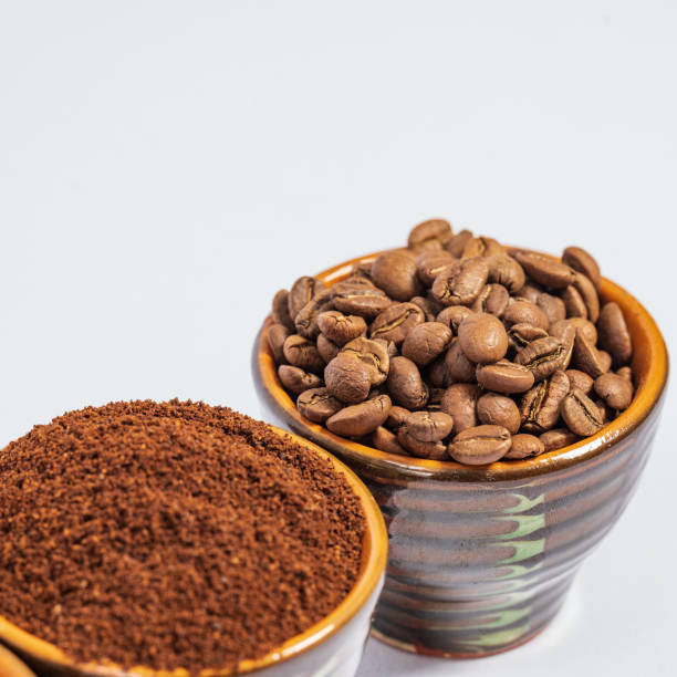 istock Cups with roasted coffee beans and ground coffee, white background and copy space. 1439521117