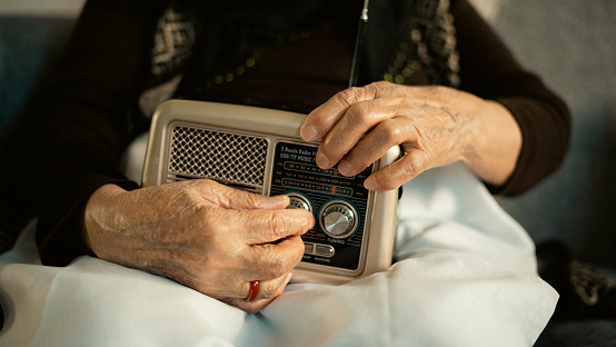 Close-up old woman holding old radio