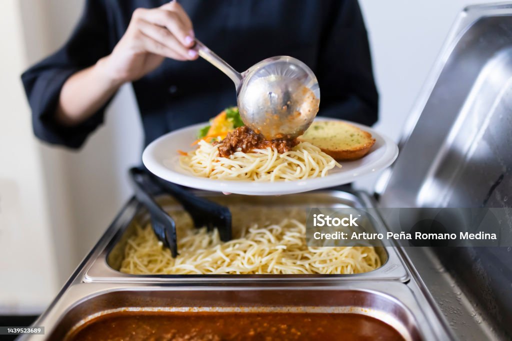Cook serving food on a plate Food And Drink Industry Stock Photo