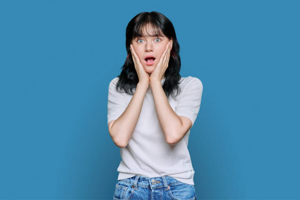 istock Young shocked woman looking at camera on blue background 1439525167