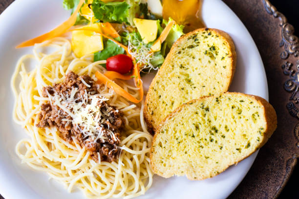 Spaghetti pasta with pieces of chicken mixed with red and green bell peppers.