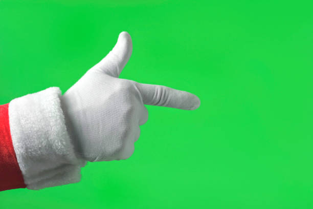 рука санта-клауса указывает на переднюю часть указательным пальцем, изолированным на зеленом фоне. заживать. рука в белой перчатке указыва� - close up touchpad computer index finger стоковые фото и изображения