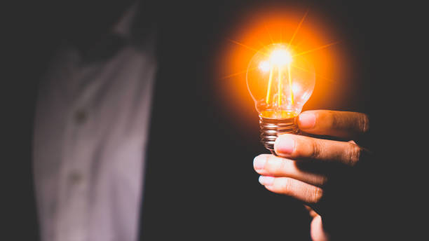 istock Man's hand holding a light bulb. Ideas, innovations and inspiration. Creative idea with sparkling light bulbs. concept of crisis 1439529058