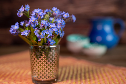 Forget-me-not Bouquet with candle on wooden table