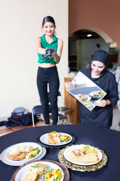 Digital content creator with chef taking photos and videos for restaurant