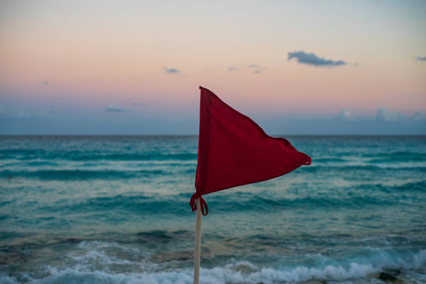 Red Flag on Beach Marking unsafe Water for Swimming stock photo