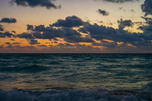Sunrays coming through Clouds at Sunrise over Water