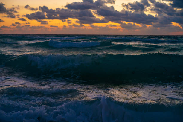 Sunrays coming through Clouds at Sunrise over Water