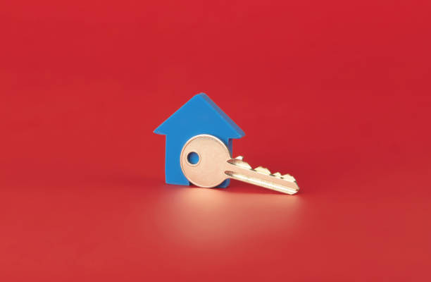 house key with blue house isolated on red background