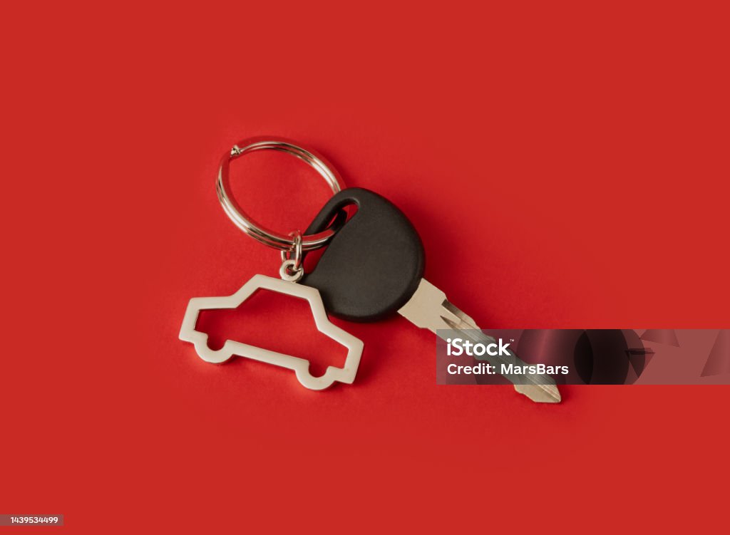 car key with keychain on red background Car Stock Photo