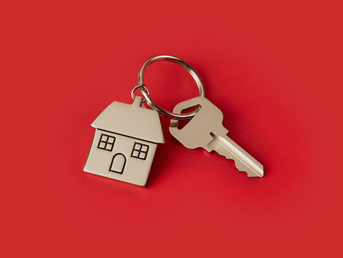 House key with keychain isolated on red background