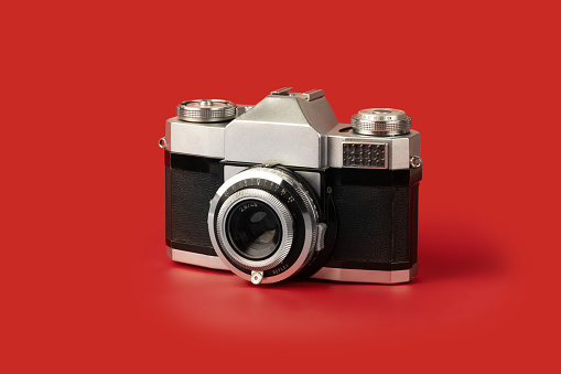 vintage photographic camera isolated on red background