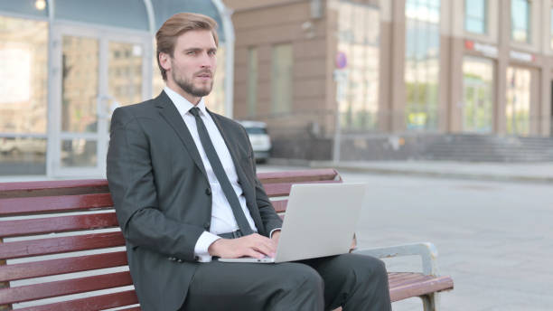 istock Rejecting Businessman in Denial While using Laptop Sitting Outdoor on Bench 1439535477