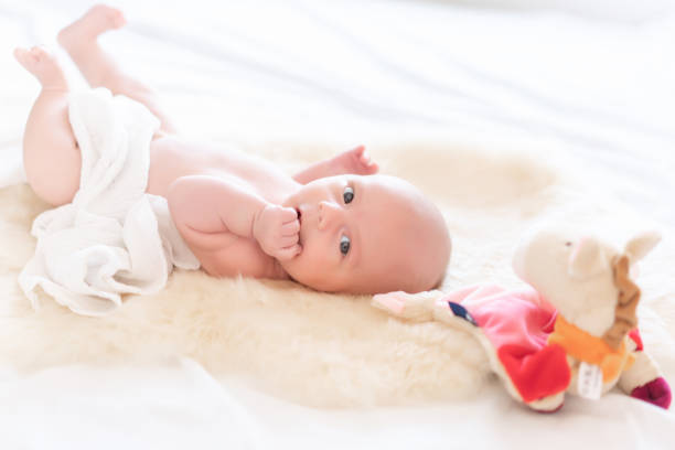 istock Cute newborn baby posing for camera after shower on white blanket 1439536018