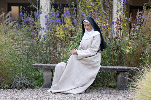 Walking nun in monastery and garden